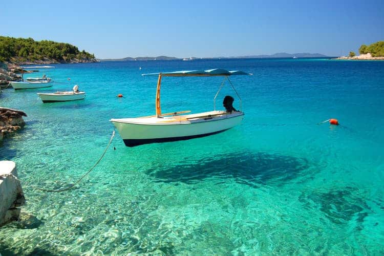 Adriatic Sea turquoise waters with a boat that looks like it's floating in mid air.