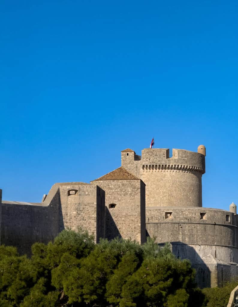 A panoramic view of Dubrovnik’s City Walls, showcasing the historic fortifications, terracotta rooftops, and the shimmering Adriatic Sea.
