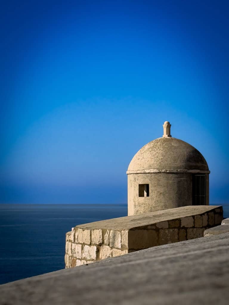 A historic tower on Dubrovnik’s City Walls, overlooking the terracotta rooftops and the blue Adriatic Sea.