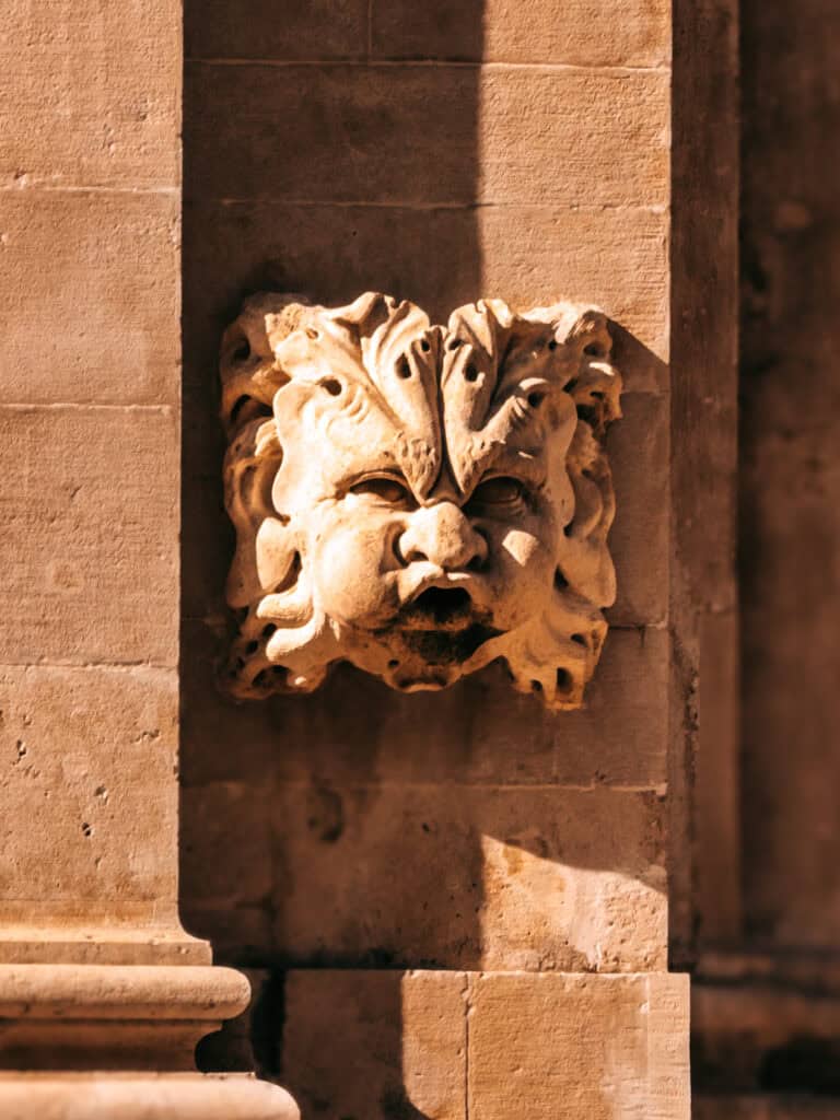 : A close-up of the Maskeron statue in Dubrovnik, a historic stone carving surrounded by local legends and folklore.
